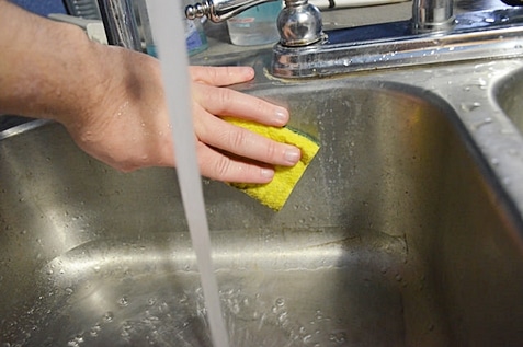 Person scrubbing the sink