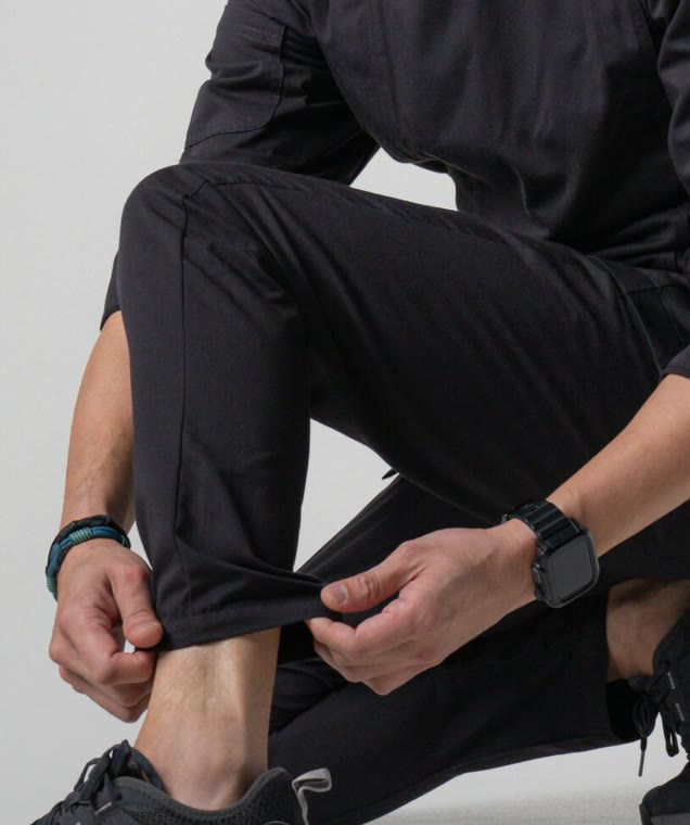 Chef crouching in black Cutting Edge chef pants and black sneakers