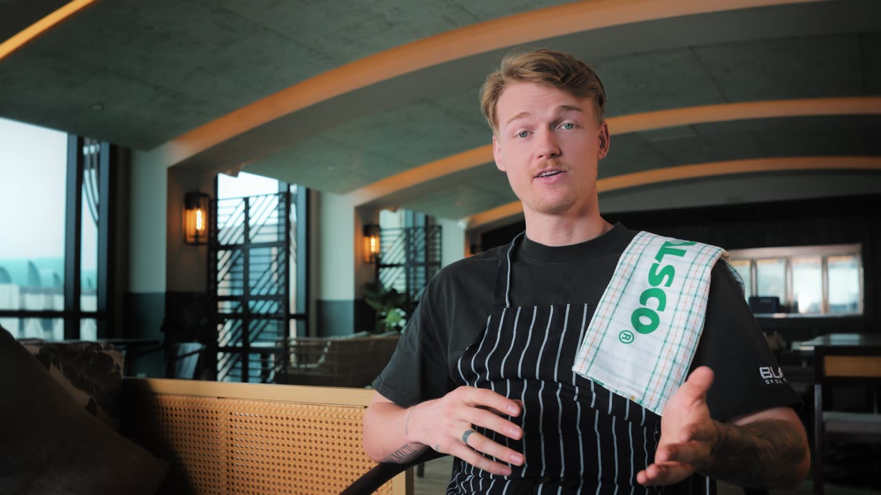 Christopher, chef at Sol & Ora, with an Alsco kitchen towel on his shoulder, video testimonial for Alsco Uniforms Singapore